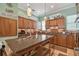 Charming kitchen with granite countertops, wood cabinets, a functional center island, and modern appliances at 1326 Apollo Beach S Blvd, Apollo Beach, FL 33572