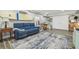 Inviting living room featuring a blue sofa, surfboard wall decor, and decorative rug on wood-look flooring at 1326 Apollo Beach S Blvd, Apollo Beach, FL 33572