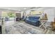 Comfortable living room with blue sofa, surfboard decor, sliding glass doors to patio, and stylish area rug at 1326 Apollo Beach S Blvd, Apollo Beach, FL 33572