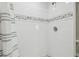 Updated shower with white tiled walls, decorative stone accents, and a modern shower head at 1326 Apollo Beach S Blvd, Apollo Beach, FL 33572