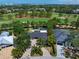 Aerial view of a luxury home, swimming pool, and manicured golf course at 16 Hibiscus Rd, Belleair, FL 33756