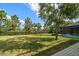 A spacious backyard with lush greenery and a glimpse of a screened pool area at 16 Hibiscus Rd, Belleair, FL 33756