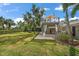 A multi-tiered deck and patio area overlooking a meticulously manicured backyard and screened in pool at 16 Hibiscus Rd, Belleair, FL 33756