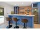 Stylish bar area with custom blue cabinets, marble countertop, and a wine refrigerator at 16 Hibiscus Rd, Belleair, FL 33756