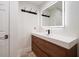 Sleek bathroom featuring modern vanity with wood cabinets, a large lighted mirror and black accents at 16 Hibiscus Rd, Belleair, FL 33756