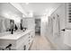 Bright bathroom boasts double vanity with sleek countertops and black hardware, complemented by wood-look tile flooring at 16 Hibiscus Rd, Belleair, FL 33756