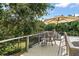 Upper-level deck with cozy seating offering views of lush backyard and mature trees, providing a tranquil retreat at 16 Hibiscus Rd, Belleair, FL 33756