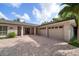 Charming single-story home with a three-car garage and a brick driveway. Landscaped for curb appeal at 16 Hibiscus Rd, Belleair, FL 33756