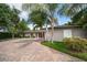 Beautiful home exterior with well-maintained landscaping, a brick driveway, and a serene setting at 16 Hibiscus Rd, Belleair, FL 33756