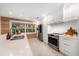 Well-lit kitchen with white cabinets, stainless steel appliances, and wood backsplash at 16 Hibiscus Rd, Belleair, FL 33756