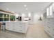Bright, modern kitchen features white cabinetry, a large island, stainless appliances, and wood-look flooring at 16 Hibiscus Rd, Belleair, FL 33756