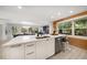 Open concept kitchen featuring white cabinets, stainless steel appliances, and an island with seating at 16 Hibiscus Rd, Belleair, FL 33756