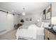 The spacious main bedroom features a decorative chandelier, barn door, and neutral color palette at 16 Hibiscus Rd, Belleair, FL 33756