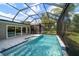 Inviting screened-in pool with a spa and waterfall feature, creating a relaxing outdoor oasis for leisure and fun at 16 Hibiscus Rd, Belleair, FL 33756