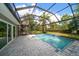 Inviting pool area featuring a screened enclosure, tile patio, and lush landscaping at 16 Hibiscus Rd, Belleair, FL 33756