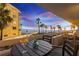 Enjoy the coastal sunset views from this balcony with seating around a small table with drinks at 17900 Gulf Blvd # 1B, Redington Shores, FL 33708