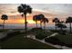 Breathtaking beach view featuring palm trees, lush landscaping and an ocean sunset at 17900 Gulf Blvd # 1B, Redington Shores, FL 33708
