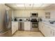 Well-equipped kitchen with stainless steel appliances, white cabinets, and functional layout at 17900 Gulf Blvd # 1B, Redington Shores, FL 33708