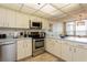 The bright kitchen features white cabinetry, stainless appliances, and functional design at 17900 Gulf Blvd # 1B, Redington Shores, FL 33708