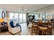 Bright living room featuring tile floors, ceiling fan, balcony access, and seating area at 17900 Gulf Blvd # 1B, Redington Shores, FL 33708
