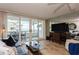 Comfortable living room with a blue sofa, glass table, tile floors, and sliding doors to the balcony at 17900 Gulf Blvd # 1B, Redington Shores, FL 33708