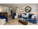 Cozy living room featuring sofa and chair set, with wood-look flooring and ample lighting at 17900 Gulf Blvd # 1B, Redington Shores, FL 33708