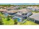 Aerial view of a two-story residence featuring a screened pool area and manicured landscaping in a residential neighborhood at 18203 Pine Hammock Blvd, Lutz, FL 33548