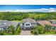 Aerial view showcasing a two-story home with a well-kept lawn and proximity to a wooded area at 18203 Pine Hammock Blvd, Lutz, FL 33548