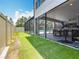 Home's exterior blends indoor and outdoor living with a screened patio and pool area, plus turf lawn at 18203 Pine Hammock Blvd, Lutz, FL 33548