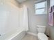 Bright bathroom showcasing a white tiled tub/shower combination and a window for natural light at 18203 Pine Hammock Blvd, Lutz, FL 33548