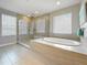 Bright bathroom featuring glass-enclosed shower and soaking tub with tile surround at 18203 Pine Hammock Blvd, Lutz, FL 33548