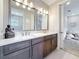 Elegant bathroom featuring double vanities with stone countertops, decorative mirrors, and neutral tones at 18203 Pine Hammock Blvd, Lutz, FL 33548