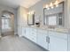 Bright bathroom featuring double vanity with granite countertop and stylish lighting fixtures at 18203 Pine Hammock Blvd, Lutz, FL 33548