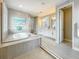Bright bathroom featuring glass-enclosed shower and soaking tub with tile surround at 18203 Pine Hammock Blvd, Lutz, FL 33548