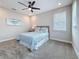 Bedroom features neutral decor, blue accents, and a ceiling fan with ample natural light at 18203 Pine Hammock Blvd, Lutz, FL 33548