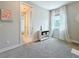 Neutral bedroom with plush carpet, open doorway, and window dressed with sheer curtains at 18203 Pine Hammock Blvd, Lutz, FL 33548