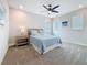 Comfortable bedroom with a blue quilted bedspread, ceiling fan, and natural light from two windows at 18203 Pine Hammock Blvd, Lutz, FL 33548