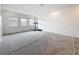 Large carpeted bonus room with exercise equipment and natural light from multiple windows at 18203 Pine Hammock Blvd, Lutz, FL 33548
