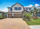 Home exterior showcasing a brick driveway, manicured lawn, and stone accents around the front door at 18203 Pine Hammock Blvd, Lutz, FL 33548