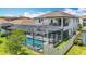 Rear exterior showcases a two-story home with a screened pool area, turf yard, and a balcony at 18203 Pine Hammock Blvd, Lutz, FL 33548