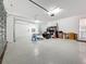 Spacious and well-lit two-car garage featuring epoxy flooring and ample storage space at 18203 Pine Hammock Blvd, Lutz, FL 33548