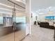 Kitchen area showcasing stainless steel refrigerator and view into living room with neutral tones at 18203 Pine Hammock Blvd, Lutz, FL 33548
