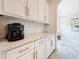 Kitchen space featuring white cabinets and granite countertops with a coffee maker on the counter at 18203 Pine Hammock Blvd, Lutz, FL 33548