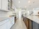Bright kitchen featuring white cabinets, stainless steel appliances, and a large island with granite countertops at 18203 Pine Hammock Blvd, Lutz, FL 33548