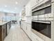 Modern kitchen with stainless steel appliances, granite countertops, white cabinets, and an adjacent dining area at 18203 Pine Hammock Blvd, Lutz, FL 33548
