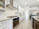 Well-appointed kitchen with white cabinetry, stainless steel appliances, granite countertops, and stylish backsplash at 18203 Pine Hammock Blvd, Lutz, FL 33548