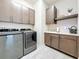 Laundry room featuring washer, dryer, sink, and storage cabinets at 18203 Pine Hammock Blvd, Lutz, FL 33548