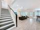 Open-concept living room features a staircase, recessed lights, and modern flooring at 18203 Pine Hammock Blvd, Lutz, FL 33548