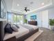 Relaxing main bedroom featuring a ceiling fan, gray carpet, balcony access, and a flatscreen TV at 18203 Pine Hammock Blvd, Lutz, FL 33548