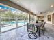 Inviting screened patio boasts a dining area with ceiling fan and views of the sparkling pool and lush backyard at 18203 Pine Hammock Blvd, Lutz, FL 33548